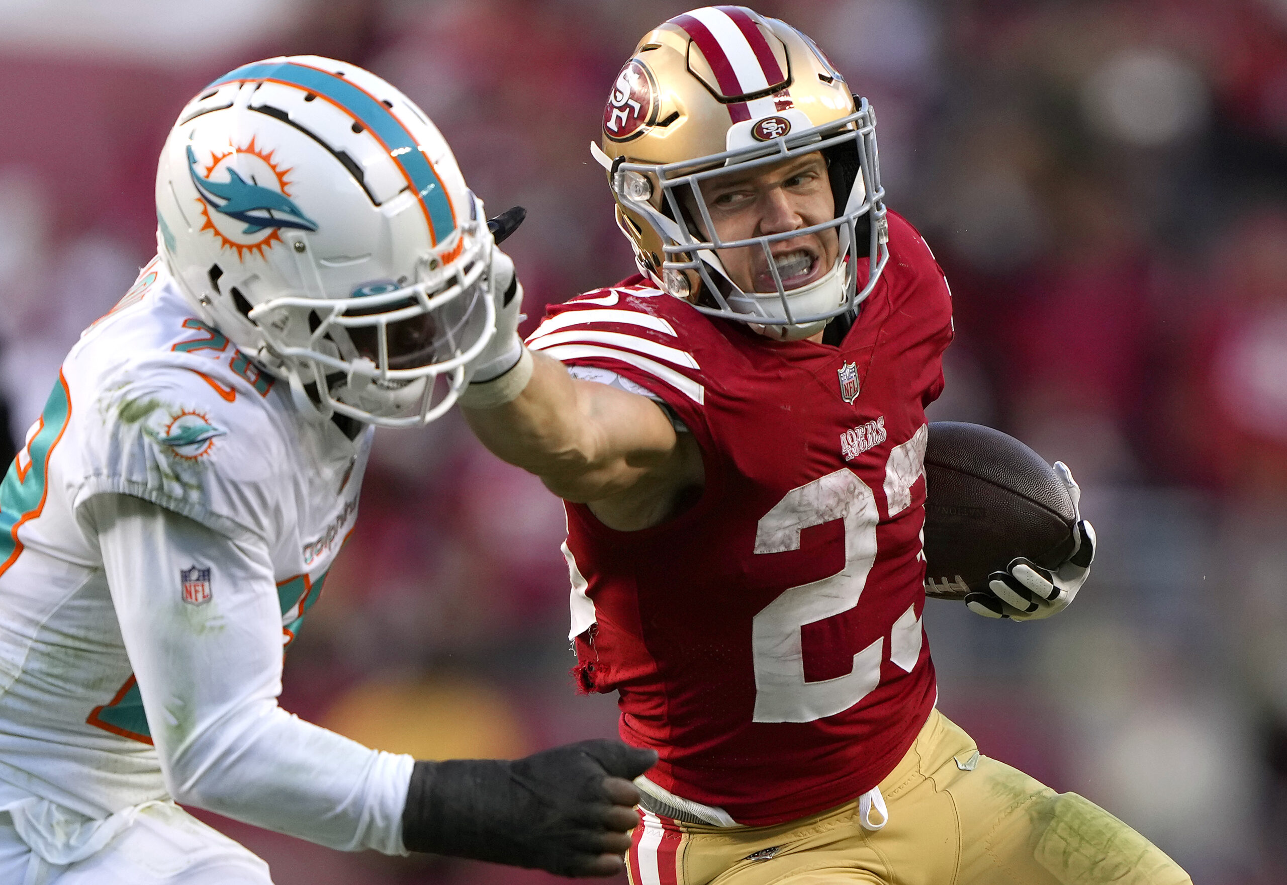 Christian McCaffrey #23 of the San Francisco 49ers fights off the tackle of Kader Kohou #28 of the Miami Dolphins during the fourth quarter of an NFL football game at Levi's Stadium on December 04, 2022 in Santa Clara, California.