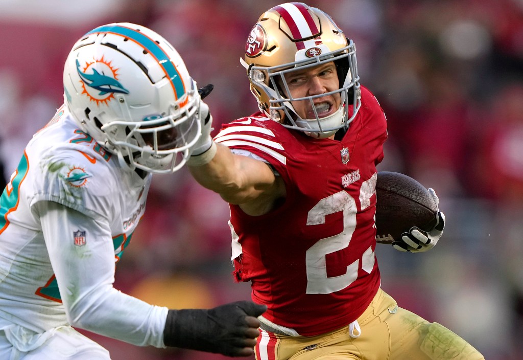 Christian McCaffrey #23 of the San Francisco 49ers fights off the tackle of Kader Kohou #28 of the Miami Dolphins during the fourth quarter of an NFL football game at Levi's Stadium on December 04, 2022 in Santa Clara, California.